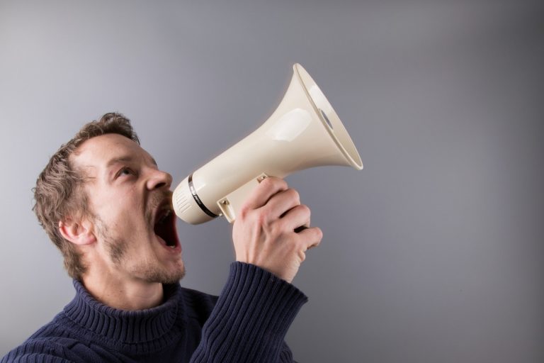 Man with a white megaphone screaming