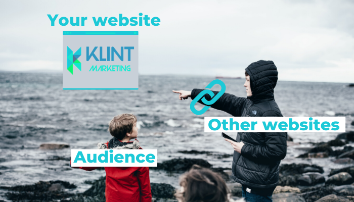A boy looks at another boy who is pointing out to the ocean. In the ocean is a Klint Marketing logo.