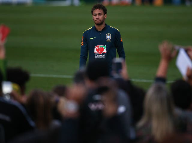Footballer Neymar looking sad whilst on the football pitch in front of a huge crowd
