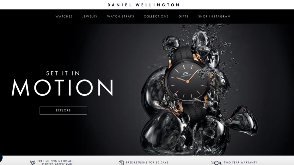 A screenshot of Daniel Wellington home page. Black background with a black watch coming out of water on the right side and words "Set it in motion" on the left.