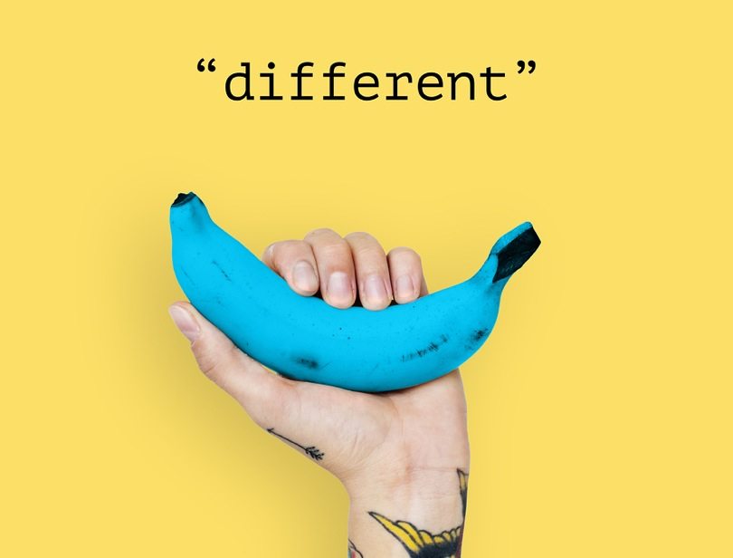 Unusual buzz campaign example. A hand holding a blue banana against the yellow background. The letters above say "different."