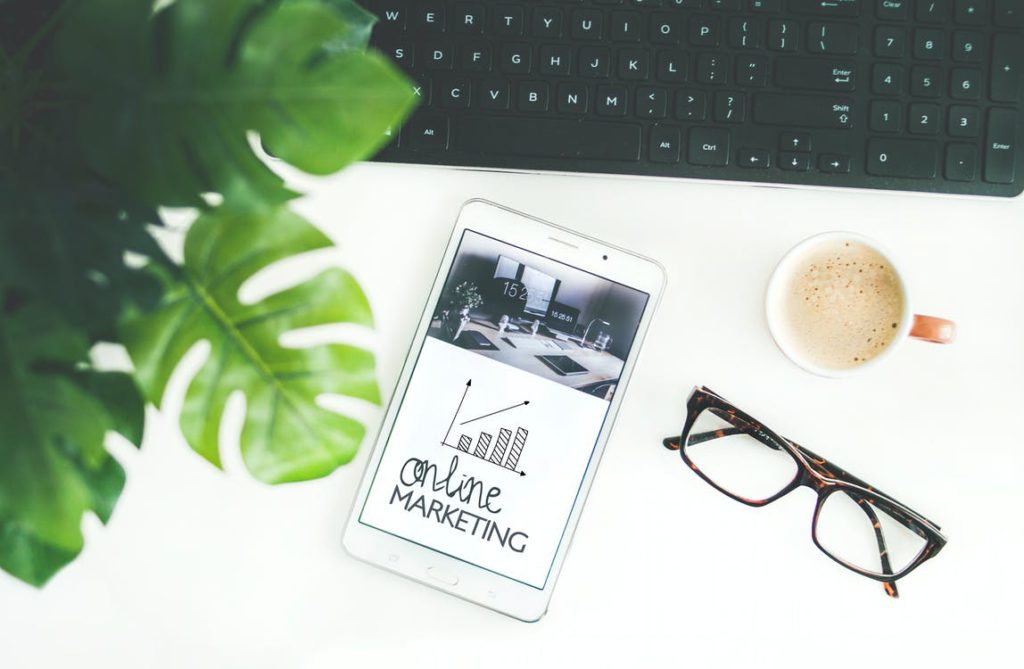 An image of a mobile screen that says "online marketing" along with other items on a desk.