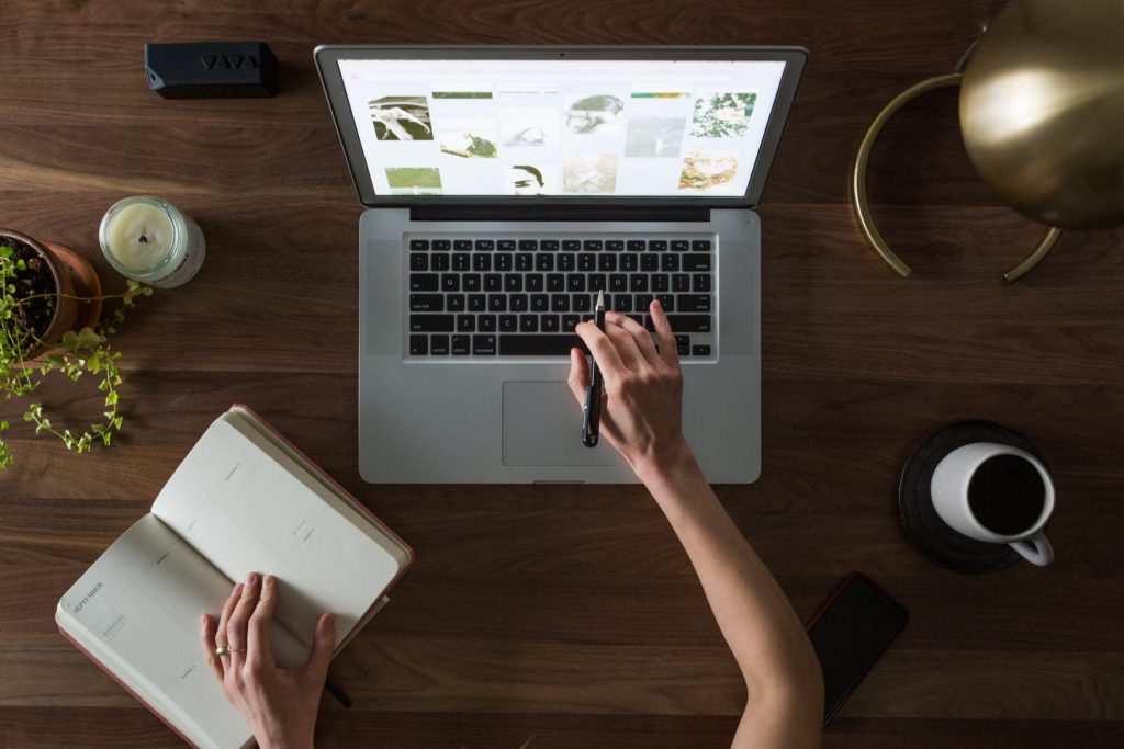 Woman navigating websites on silver laptop