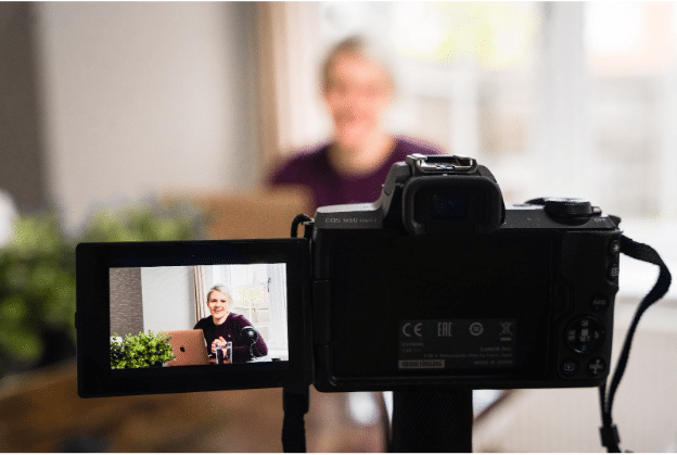 A woman recording a webinar on the camera.